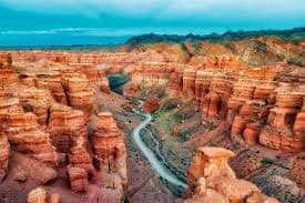 Best of Kazakhstan Aerial view of Charyn Canyon with red rock formations and winding river cutting through the landscape in Kazakhstan